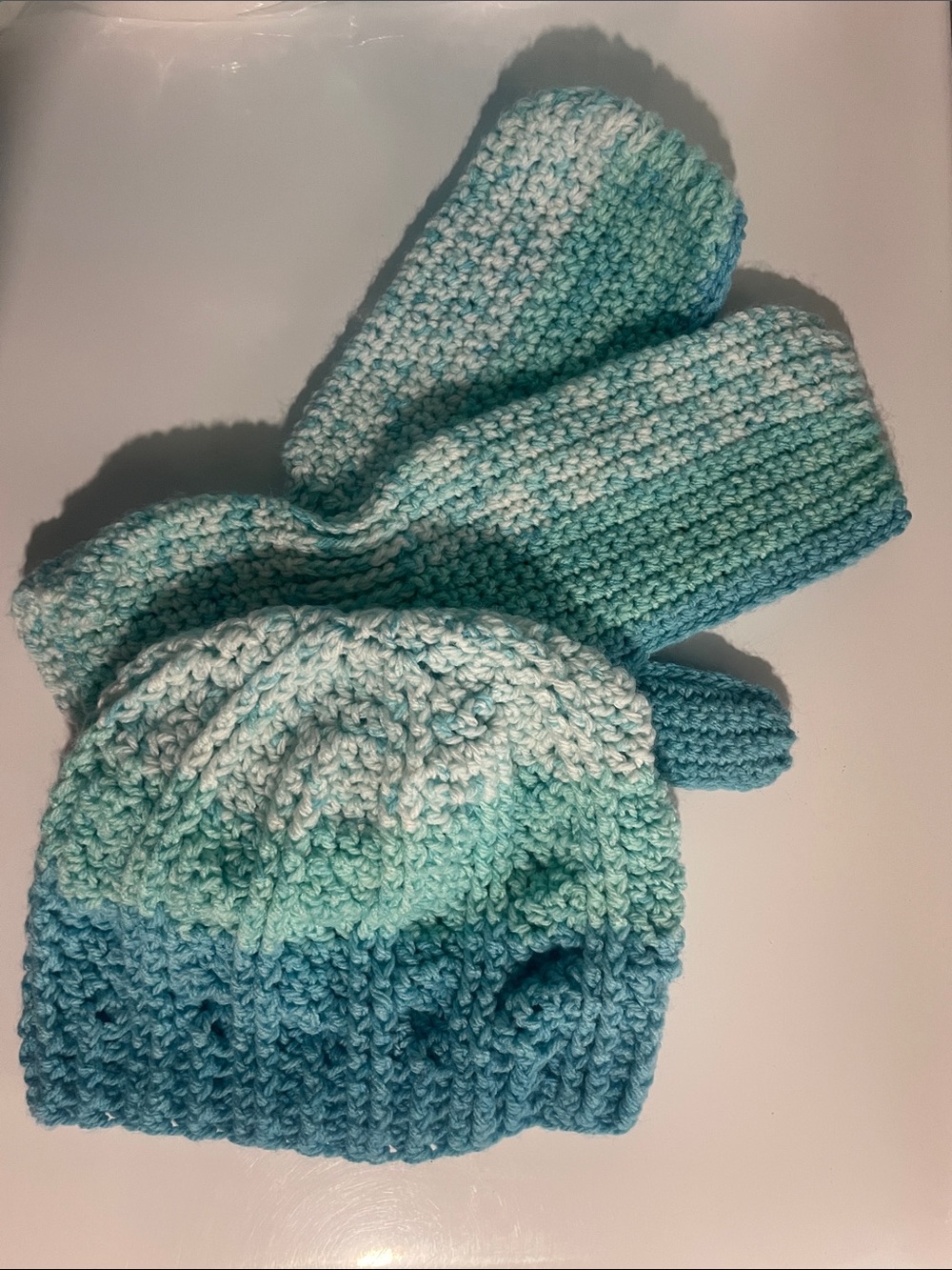 Striped aquamarine-colored mittens and hat set